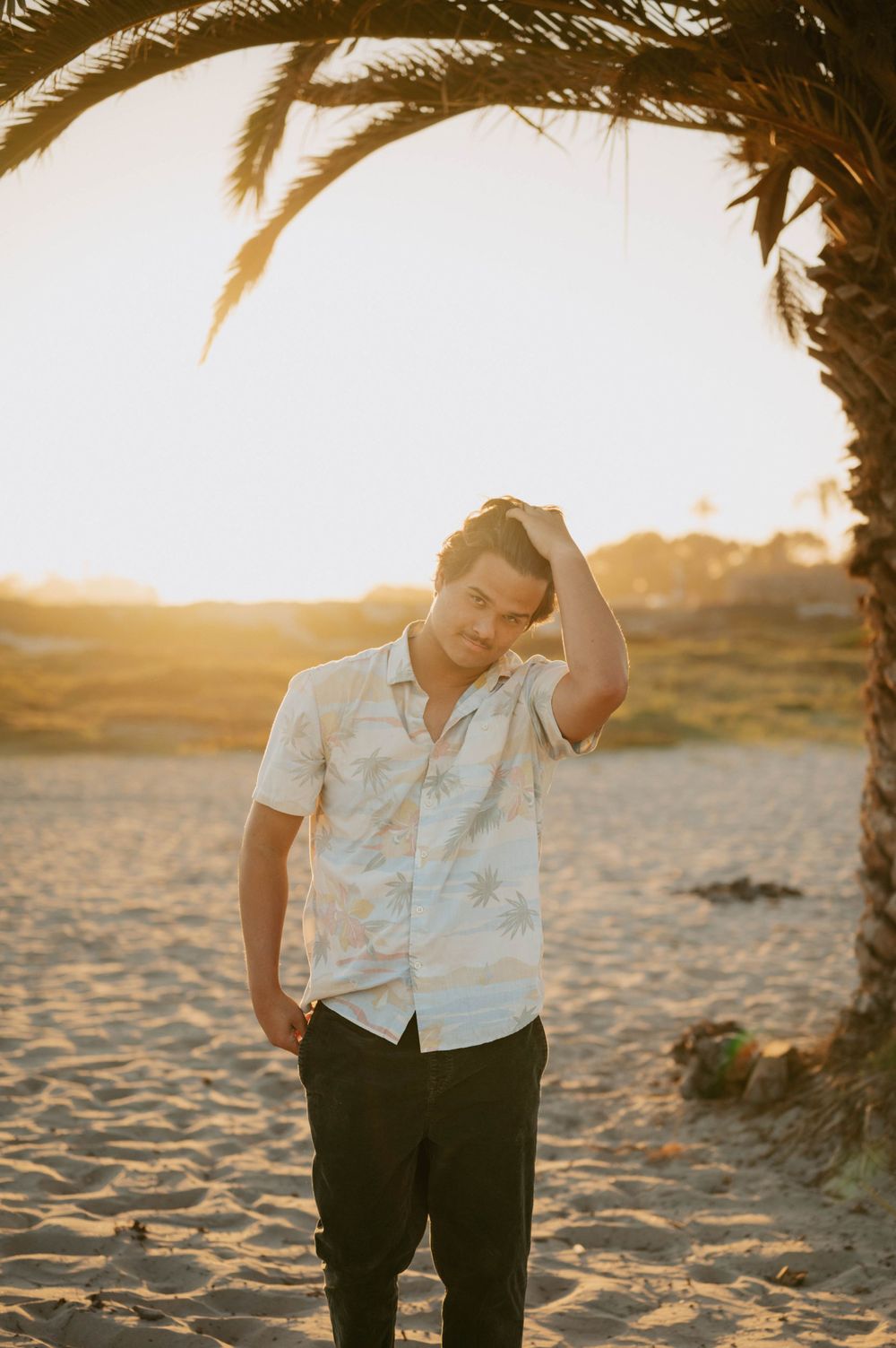 Surfer senior pictures by San Diego Photographer Tiffany Kelterer of boy walking toward camera at Coronado Beach
