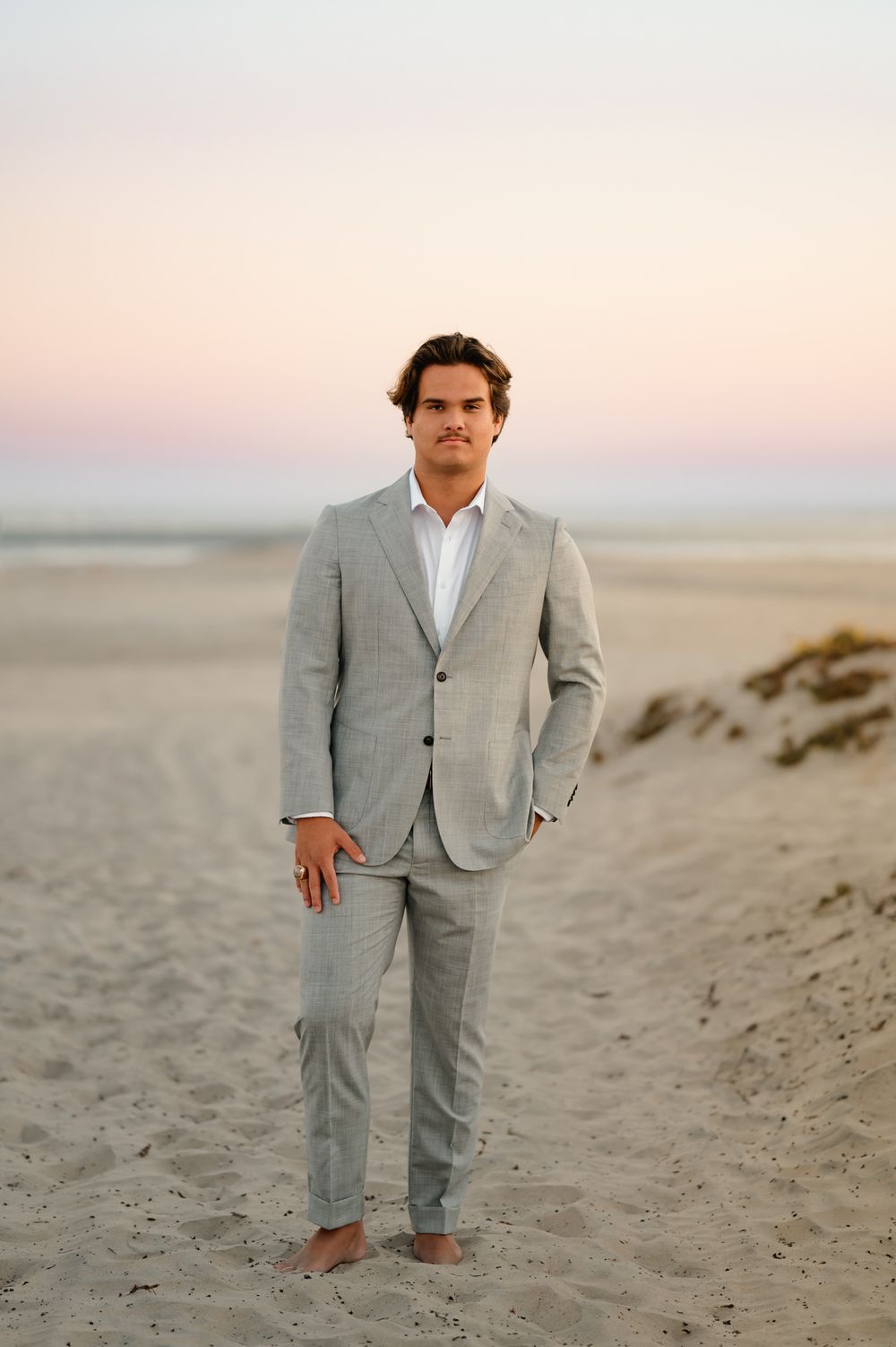 senior portrait by San Diego Photographer Tiffany Kelterer of man in suit standing on Coronado Beach