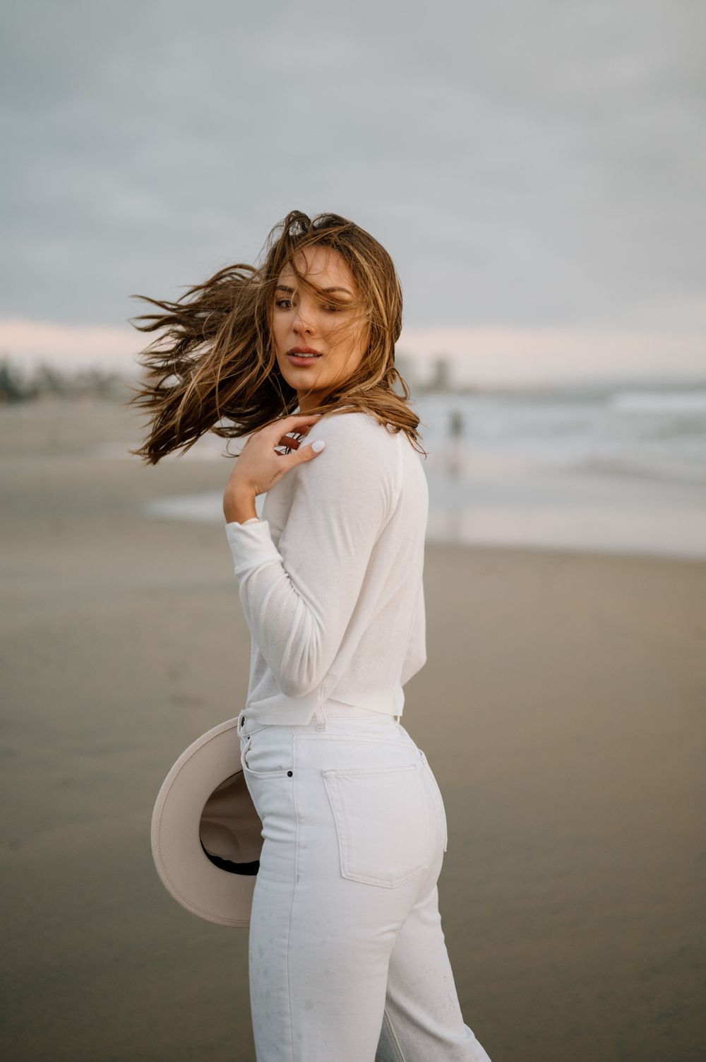 Dating portrait by San Diego Photographer Tiffany Kelterer of woman looking back at camera in the wind at Coronado Beach