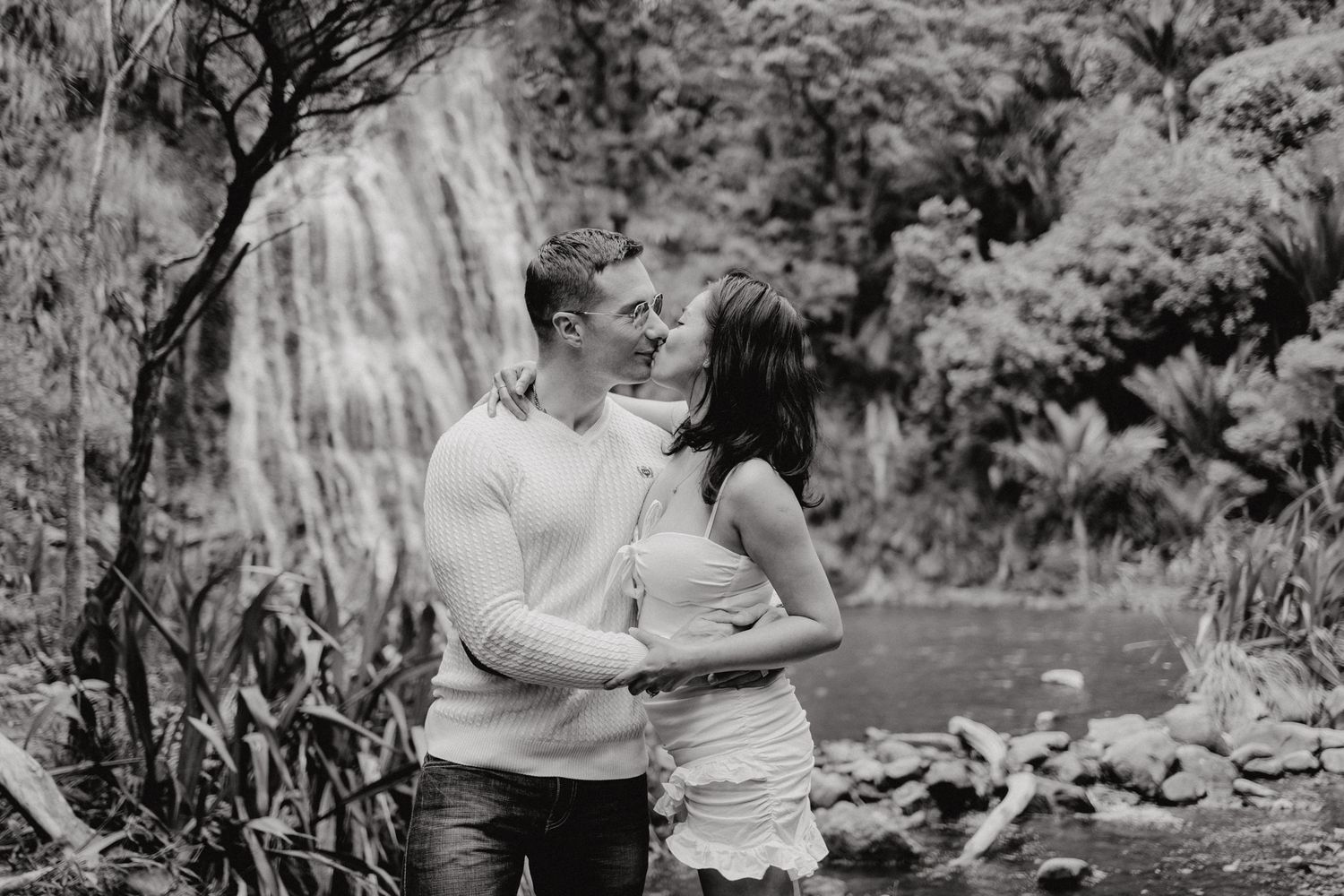 A couple kissing in Karekare Falls for their post-wedding photoshoot with Apertured Media-Auckland Wedding Photographer.