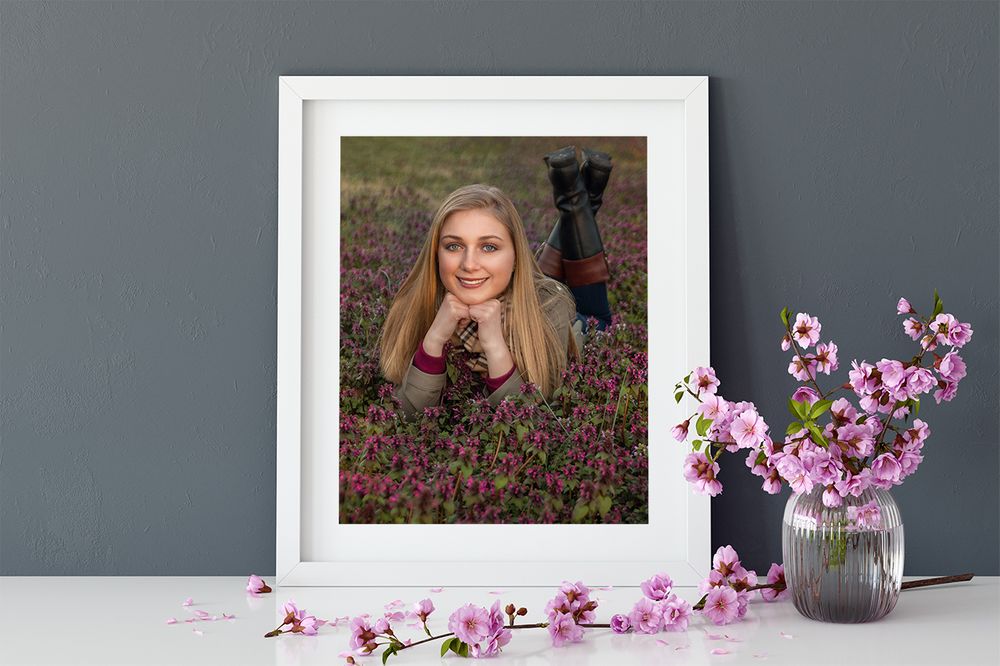 framed photo of a high school senior posing in a flower patch