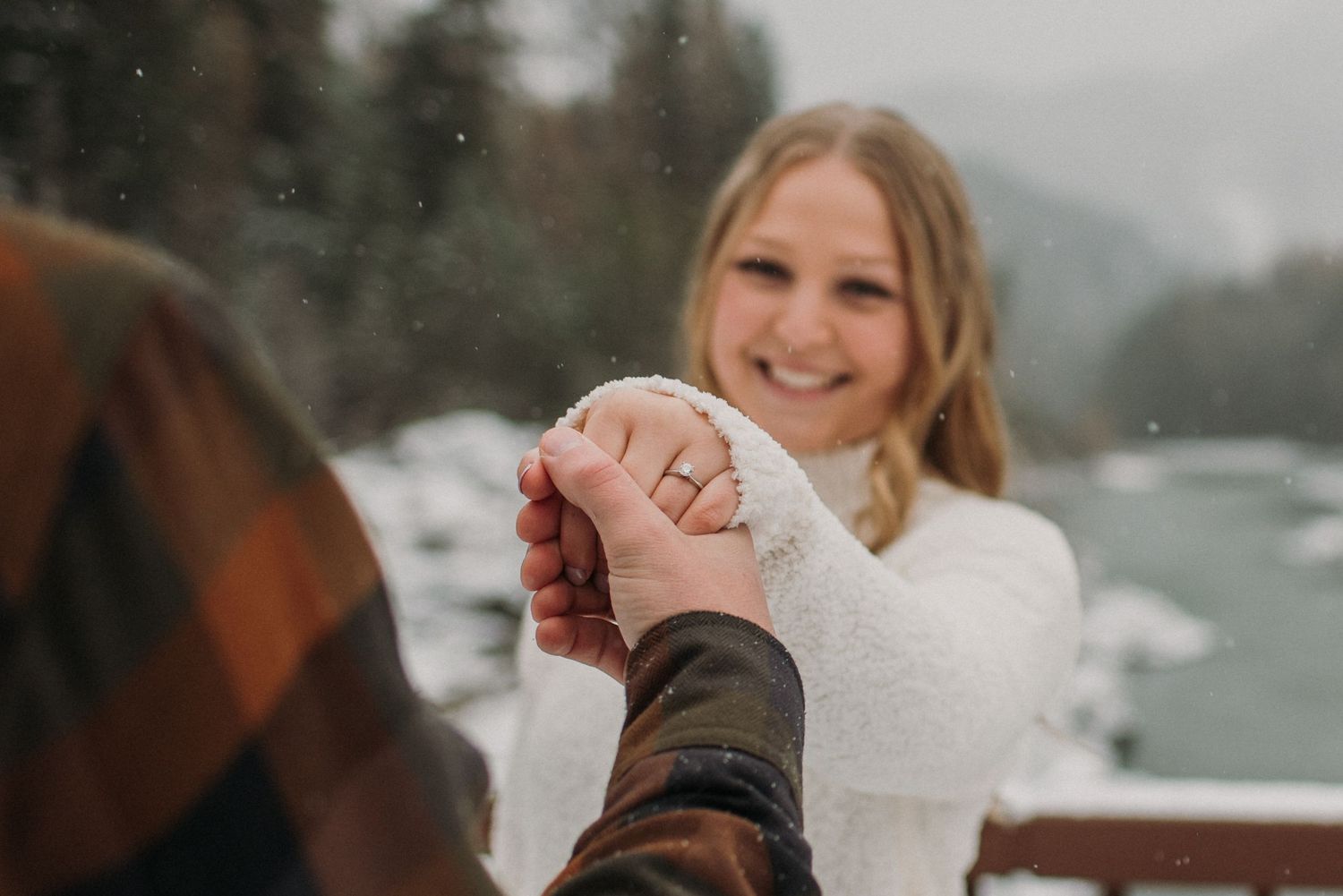 female holding out her hand with engagement ring, snowy weather in west glacier Montana