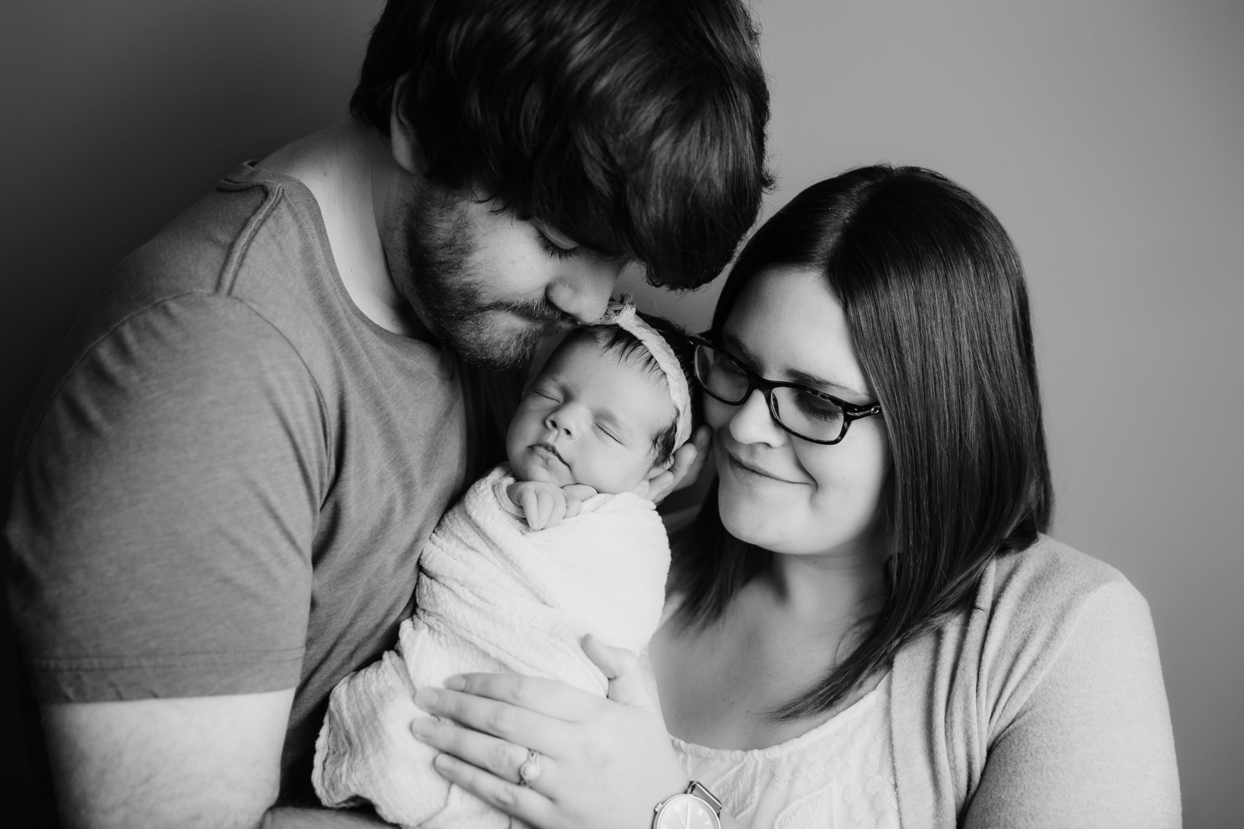 baby photographer kansas city of new parents holding baby girl in black and white