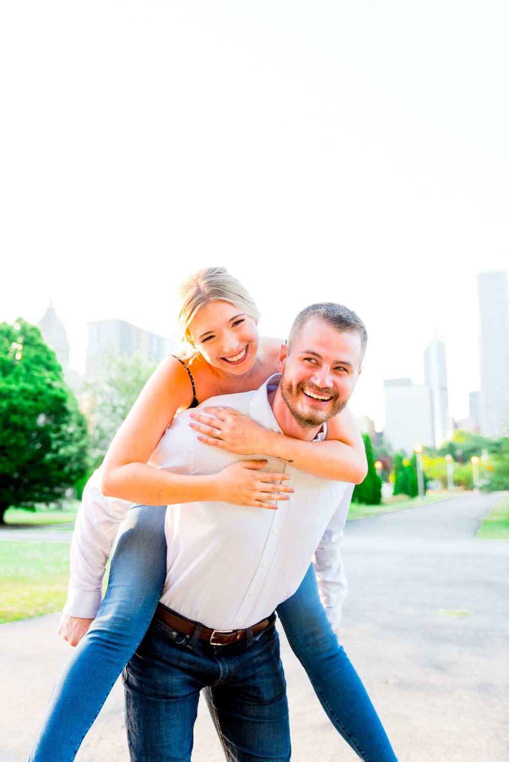 blonde woman hugging fiance from behind and both laughing