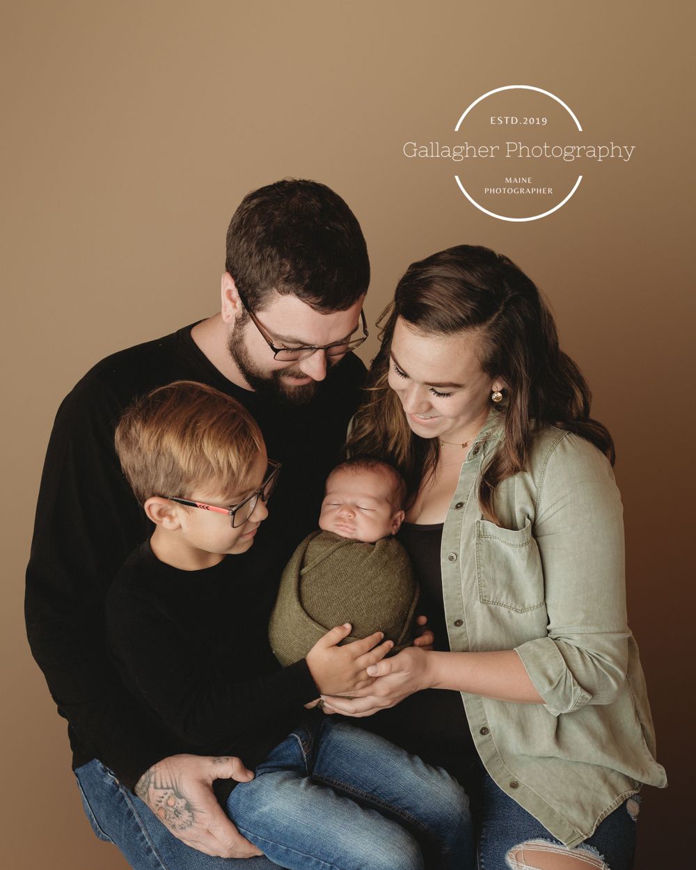 Professional newborn photo with mom, dad, and big brother