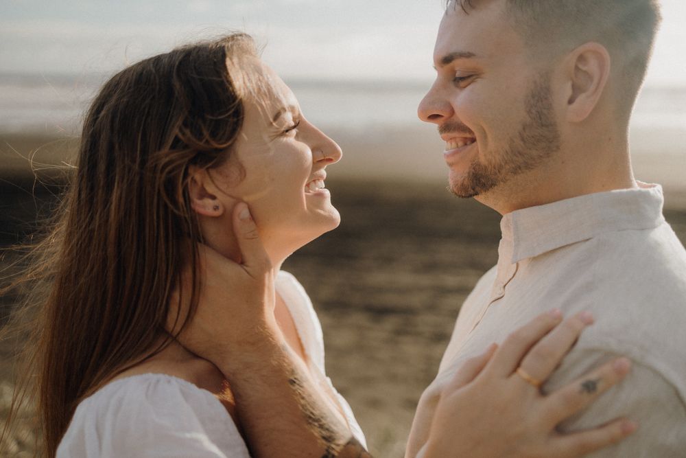 Joyful couple sharing a tender moment outdoors in natural lighting.