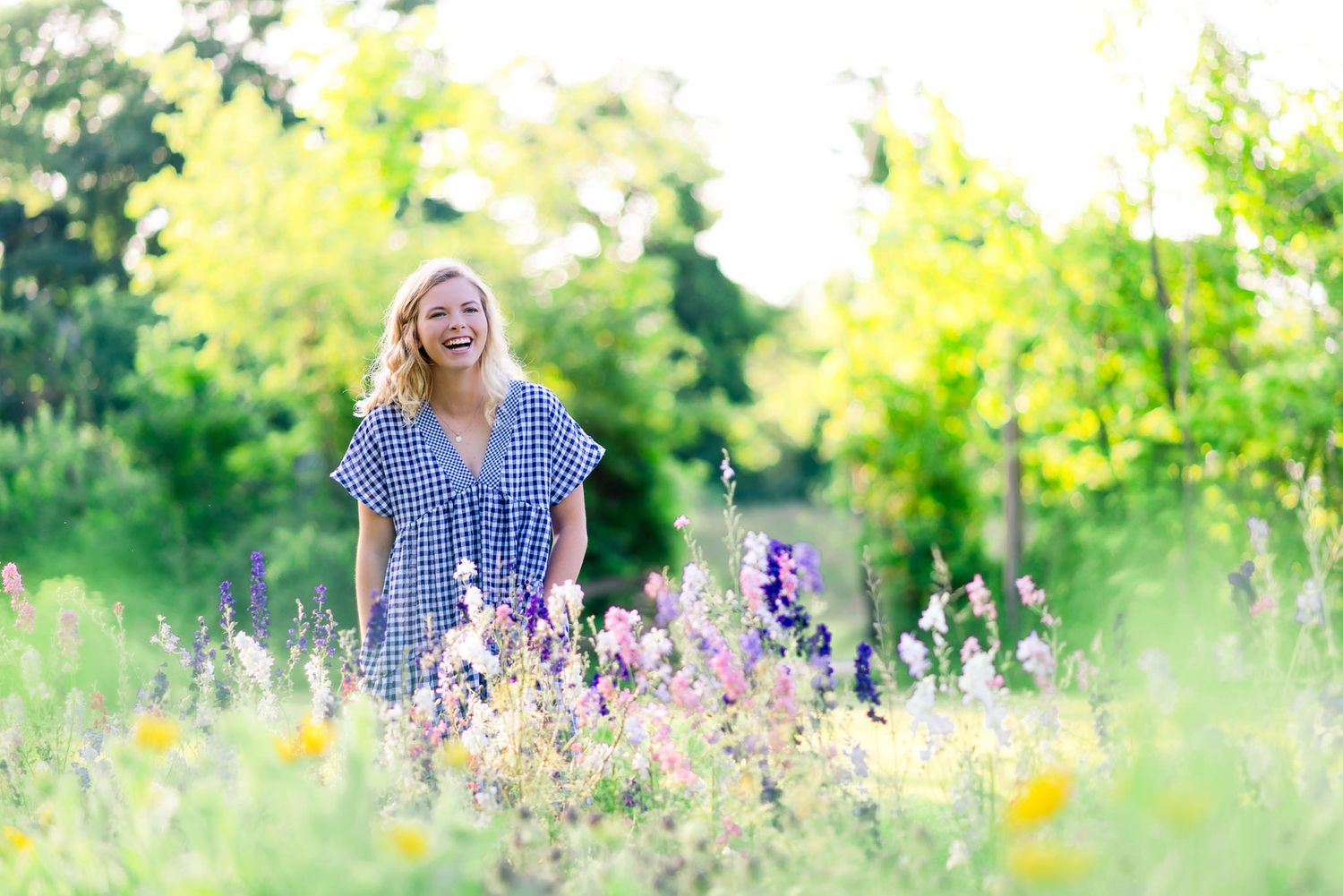 young woman laughing in field of flowers at The Marmalade Lily in Cincinnati OH for summer senior pictures