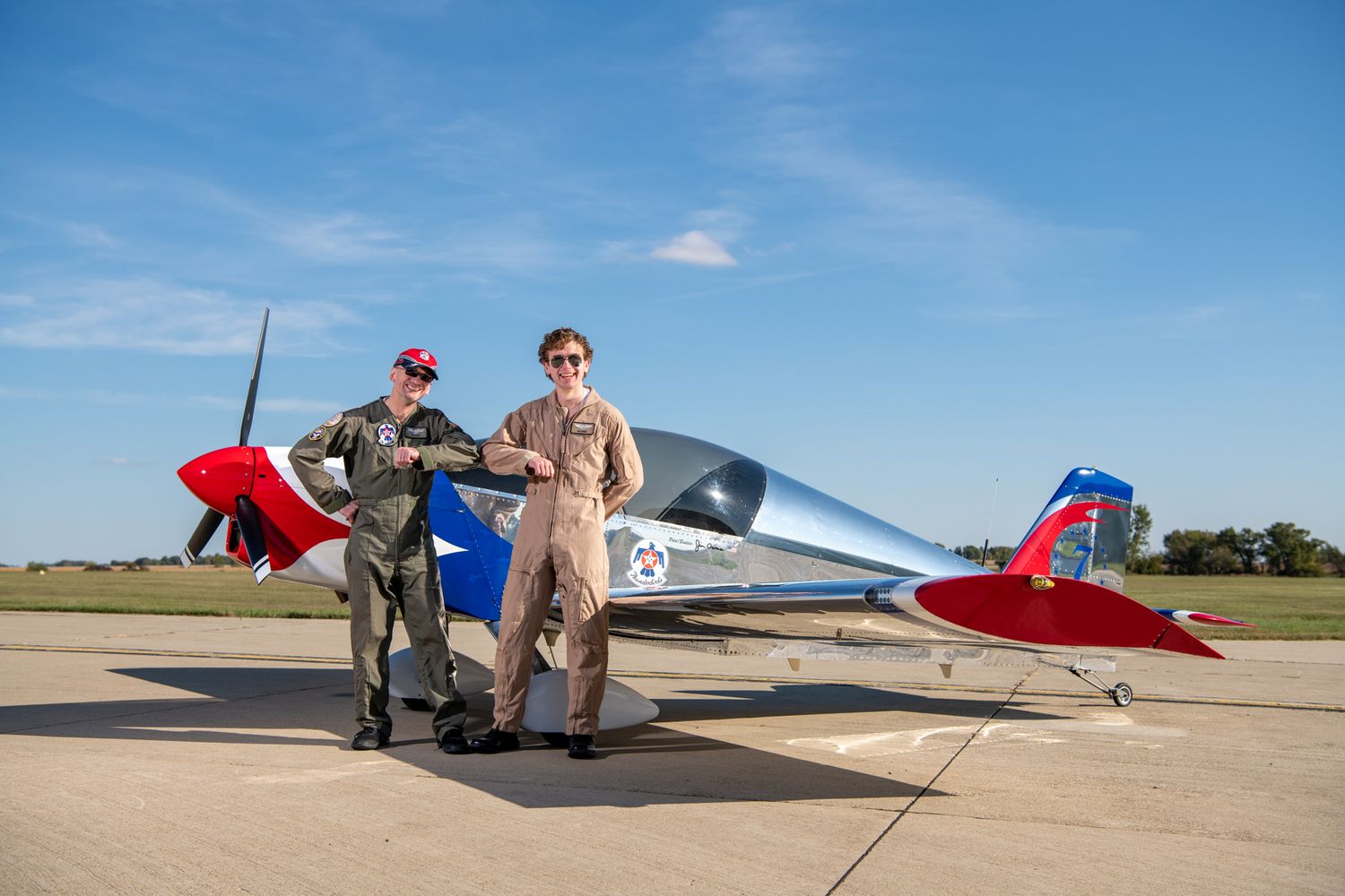 Two Aviator enthusiast pose with airplane