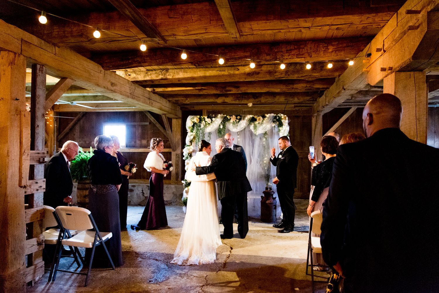 father of the bride hugging bride at the end of the aisle
