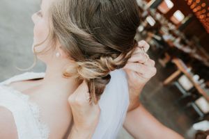 Brides hair and her mom putting in her veil