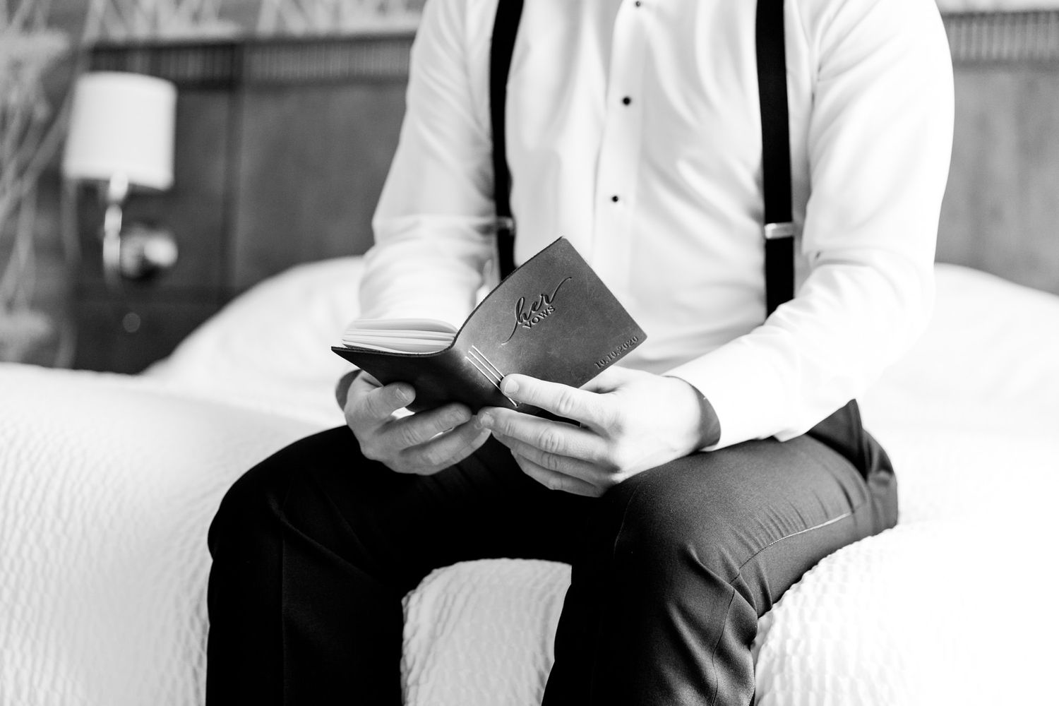 groom in black suspenders reads wifes vows before chicago wedding ceremony