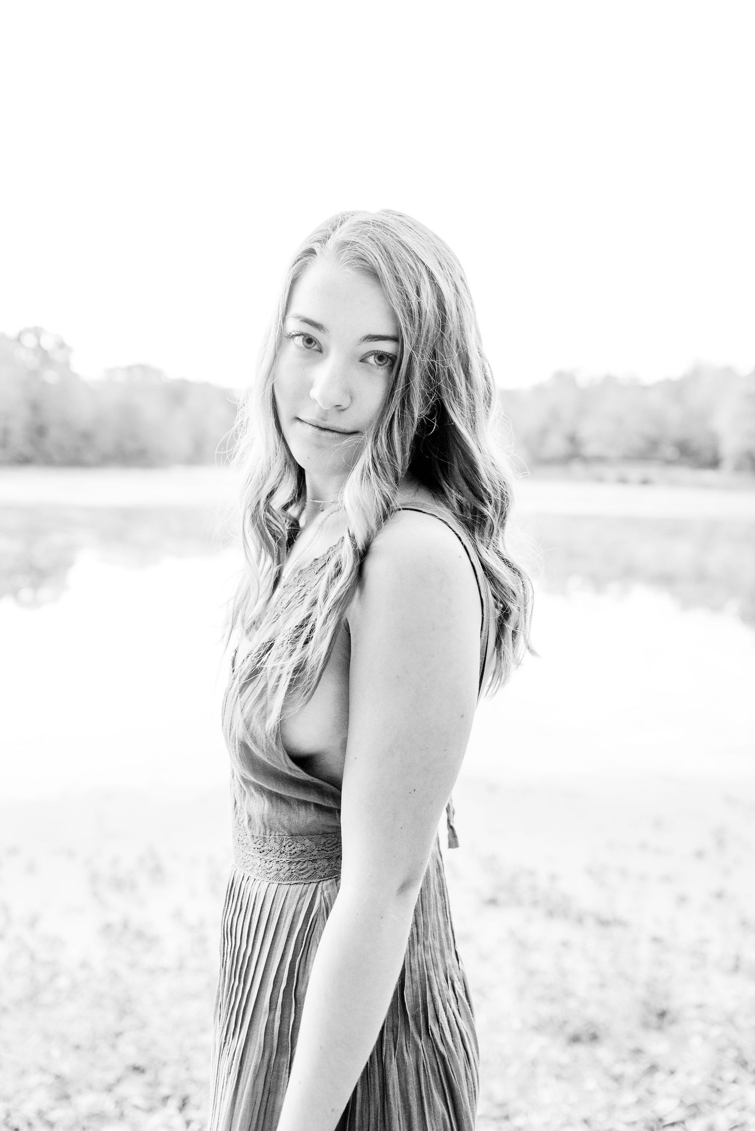 black and white image of girl standing sideways in front of a foggy lake for Chicago senior pictures