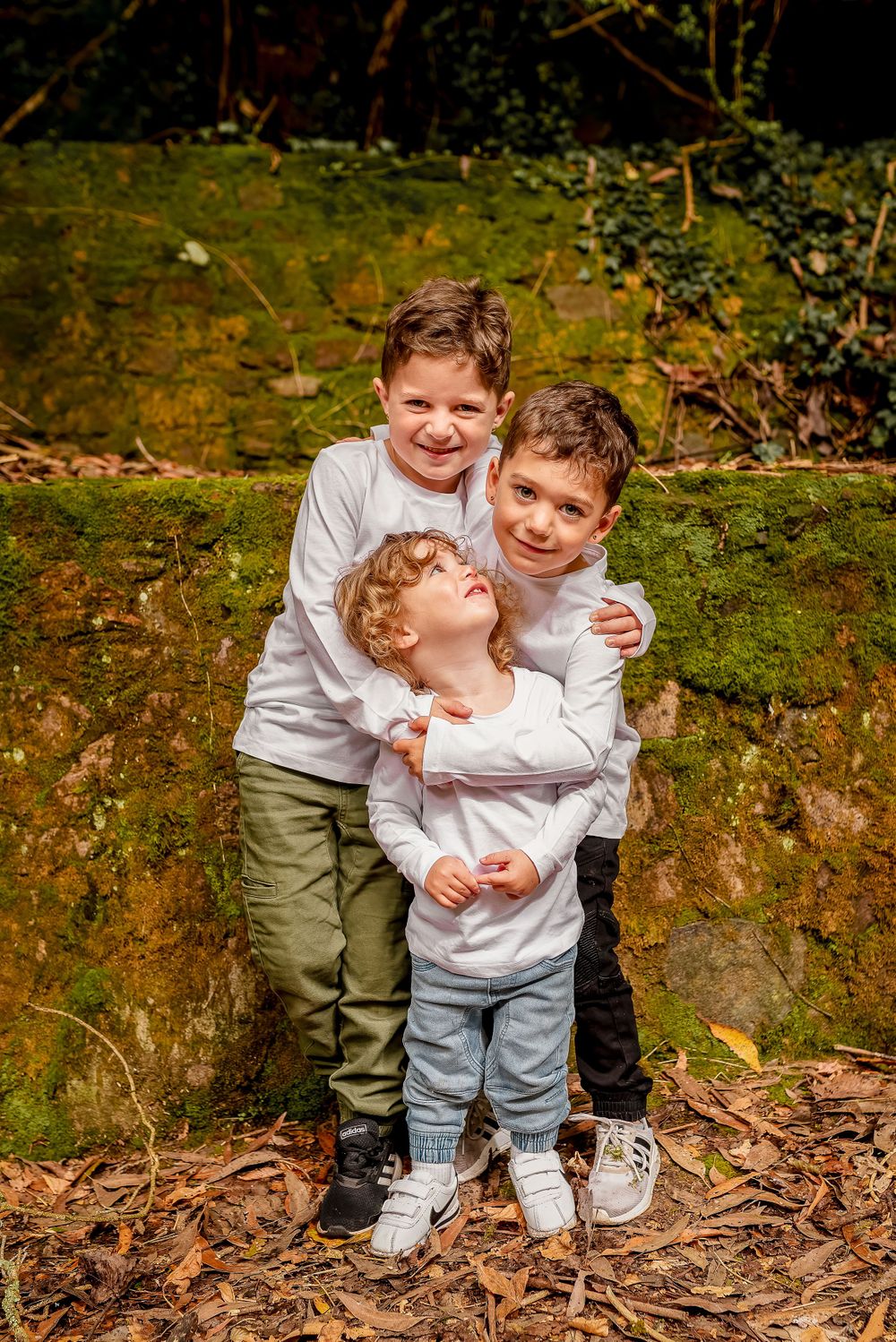 Three boys in white tshirts cuddling in private garden in Melbourne