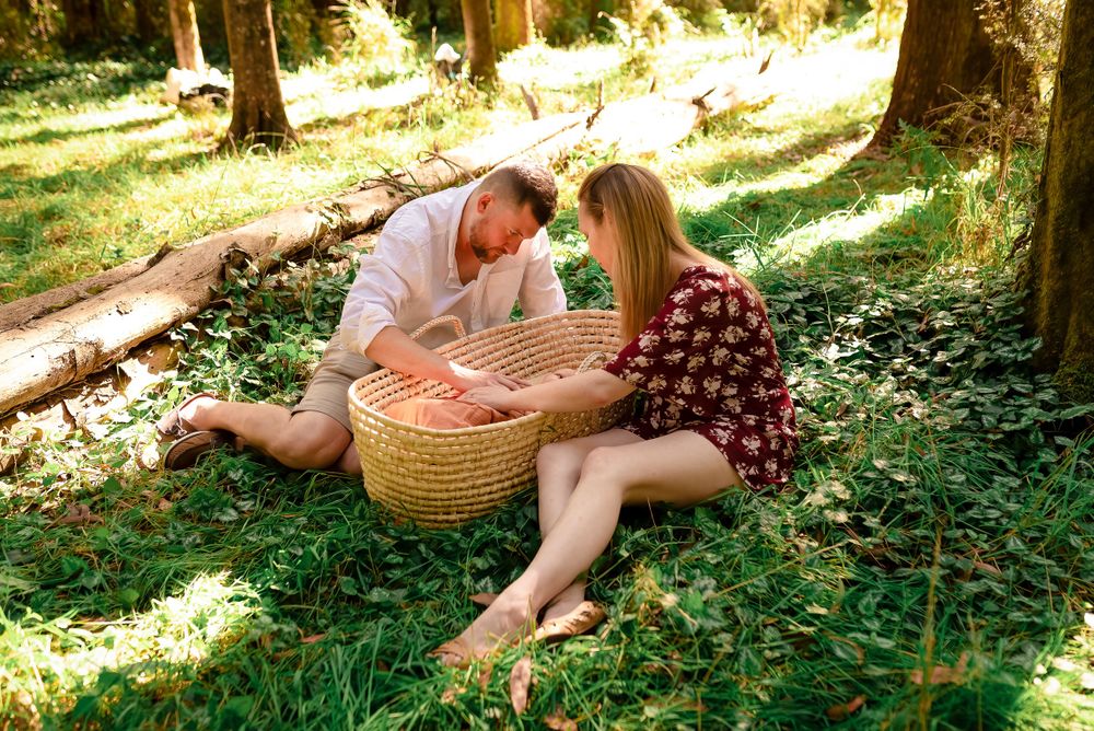 Parents gazing at baby in moses basket in Melbourne