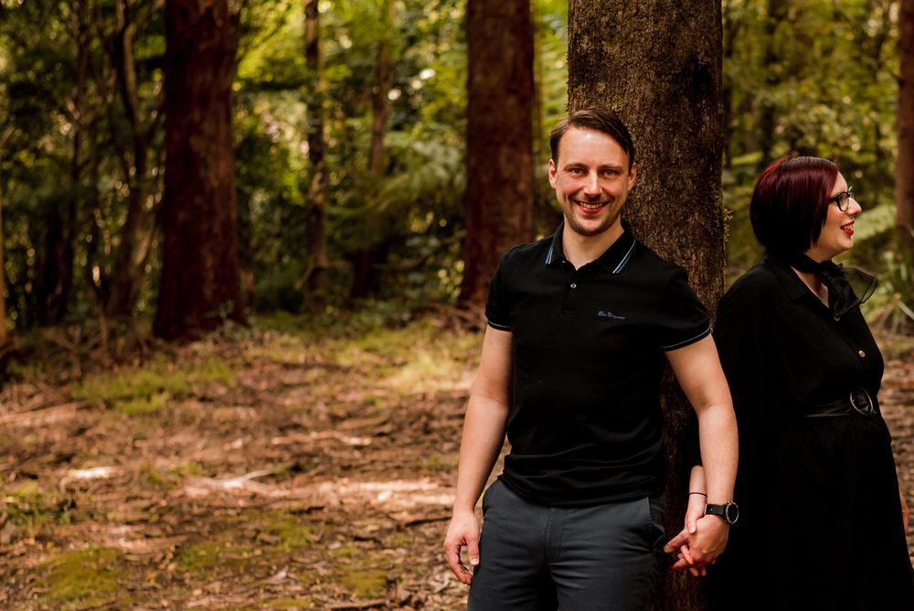 Couple leaning against a tree in forest in Sassafras