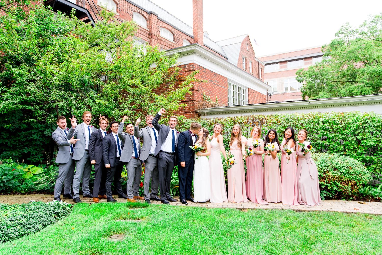 wedding party in grey and pink cheer for newlyweds at the Woman's Club of Evanston garden