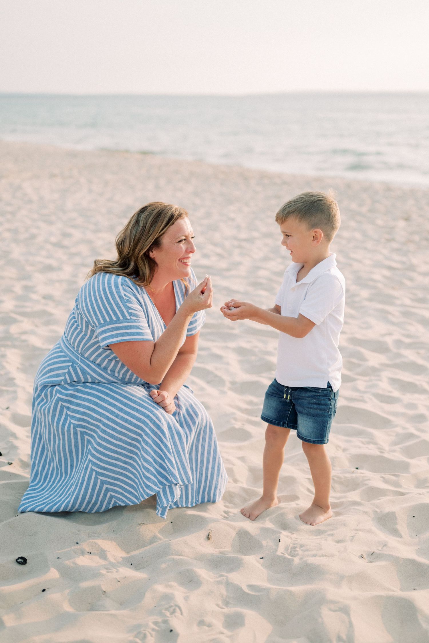 Heartwarming beach moment as they examine seashells together on the sand.