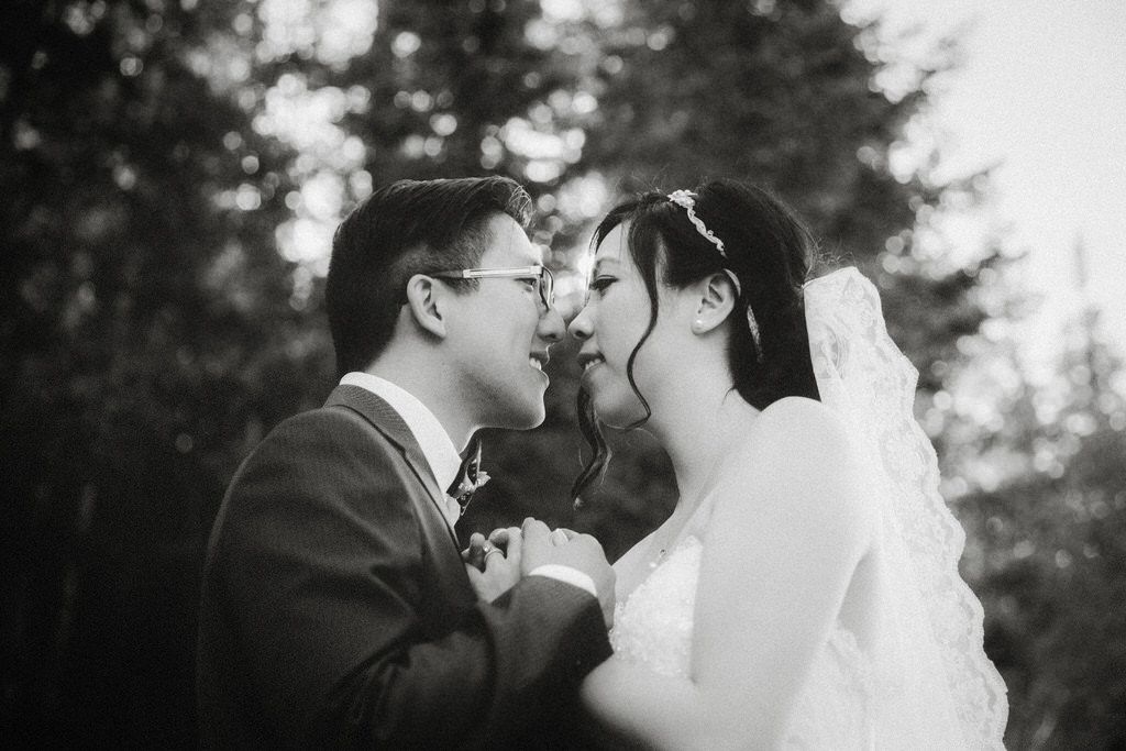 A romantic black and white portrait captures an intimate moment between newlyweds.