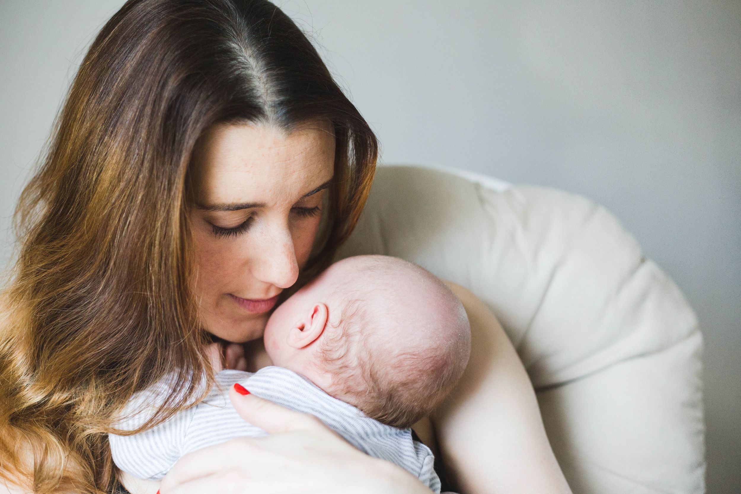 mum holding baby close to chest and face