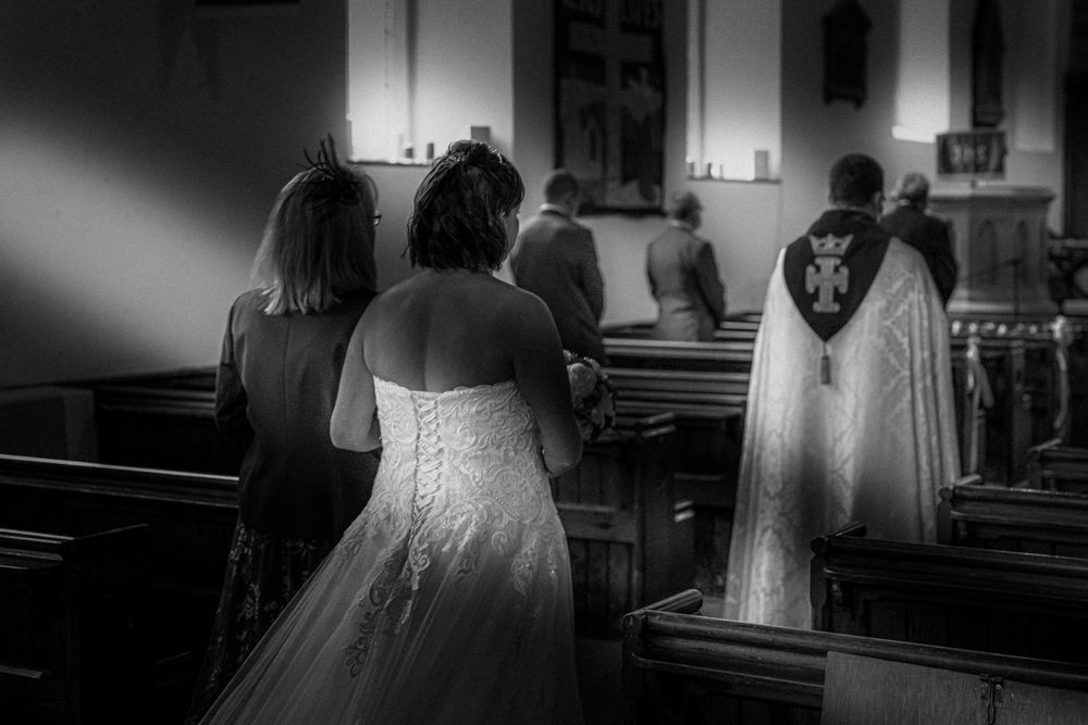 Black and white photo of bride walking up the isle in Manchester