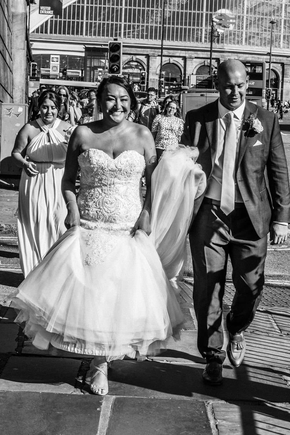 Black and white photo of bride and groom walking in Liverpool