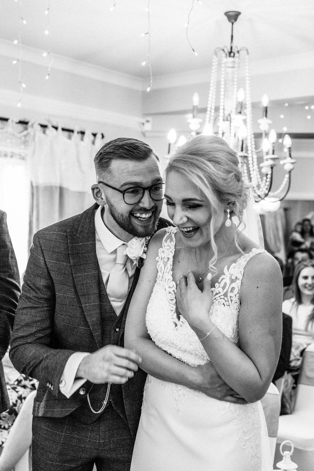 Black and white photo of bride and groom laughing