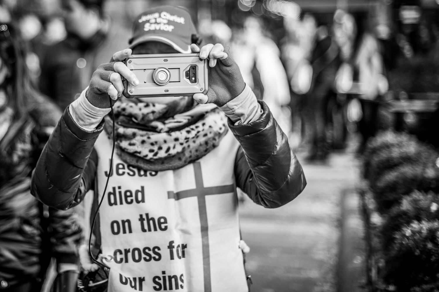 Protester with camera walking through NYC Bryant Park