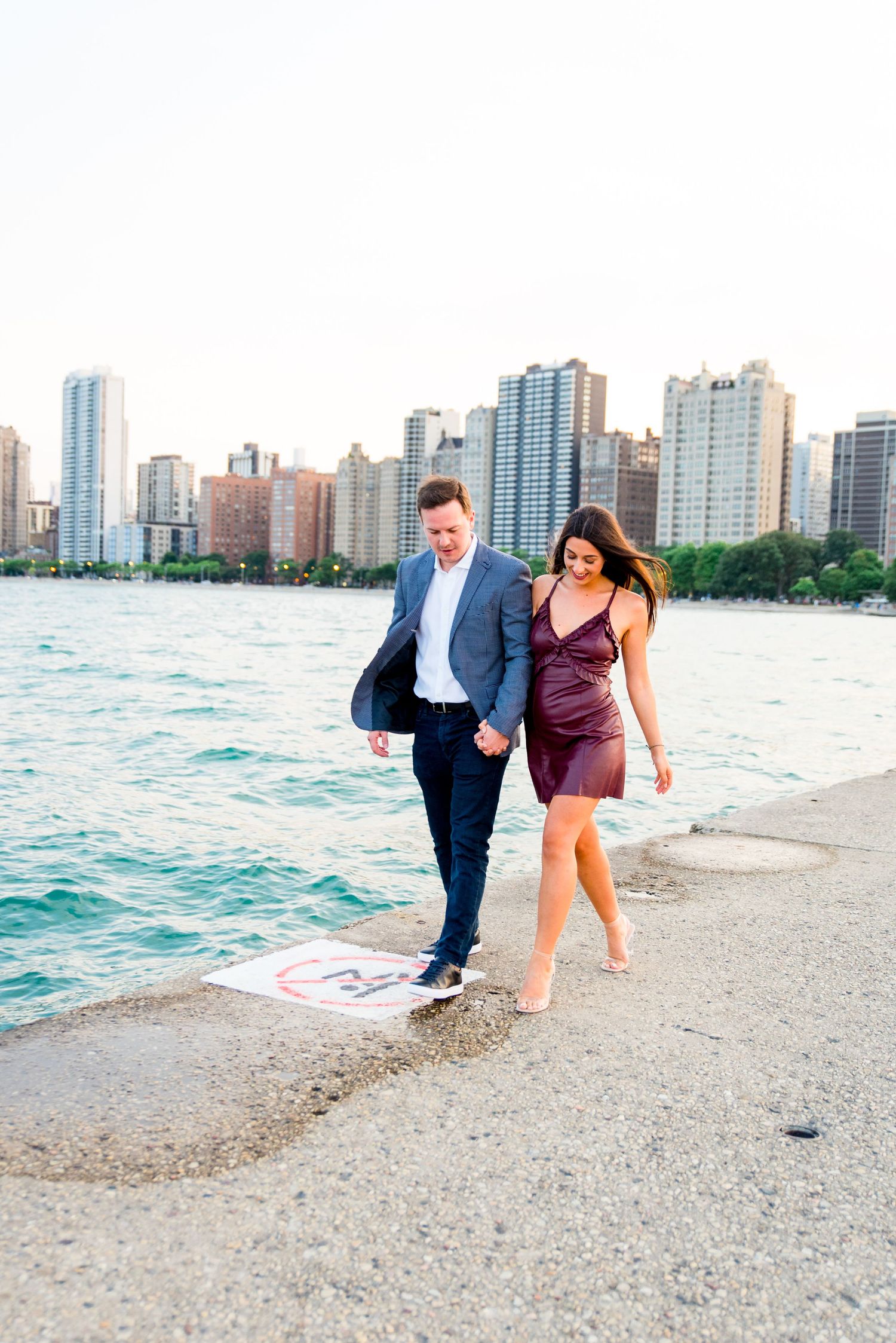 man and woman holding hands walking along pier at North Avenue Beach Chicago