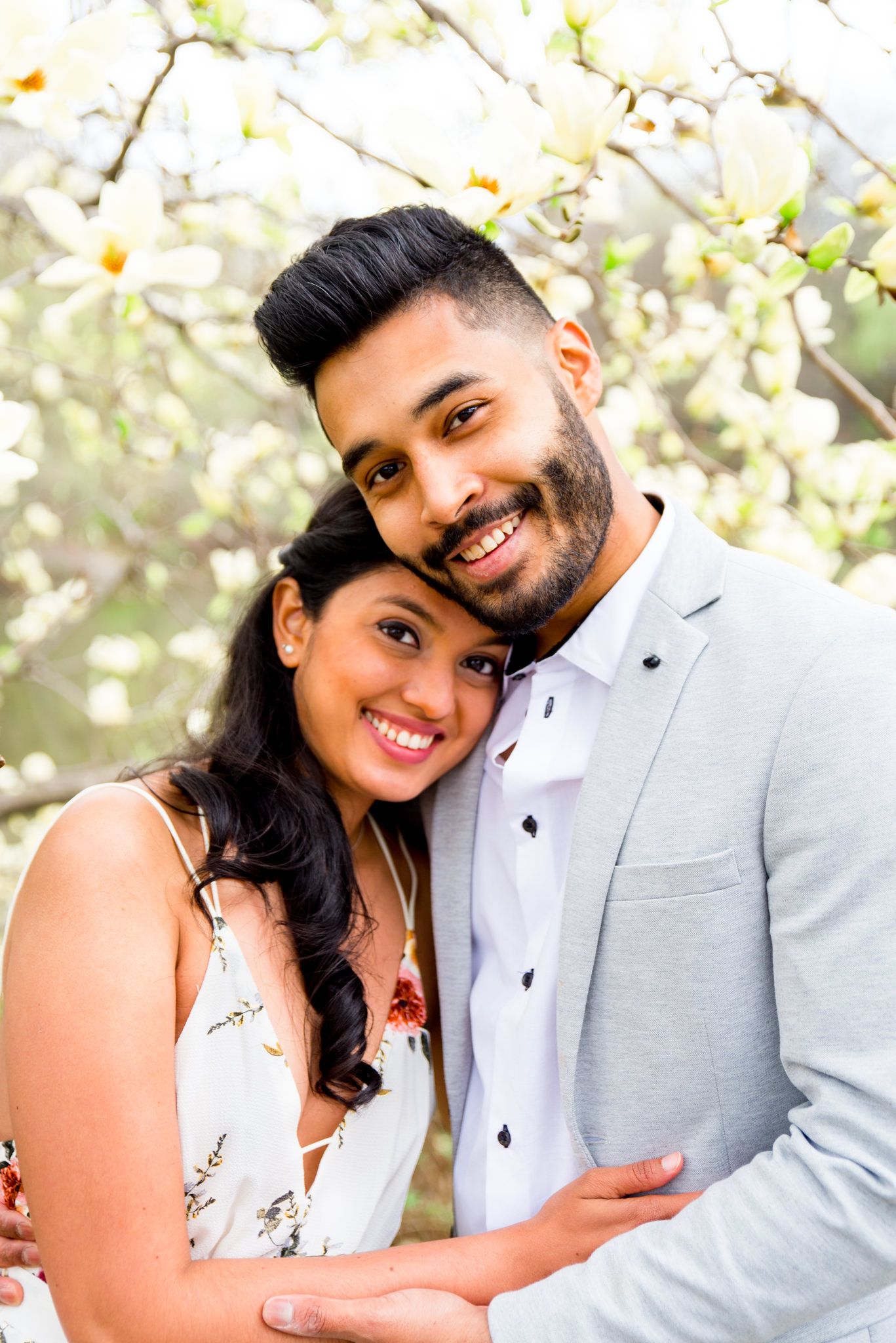Young couple hugging and laughing on bow bridge Central Park engagement photos in NYC