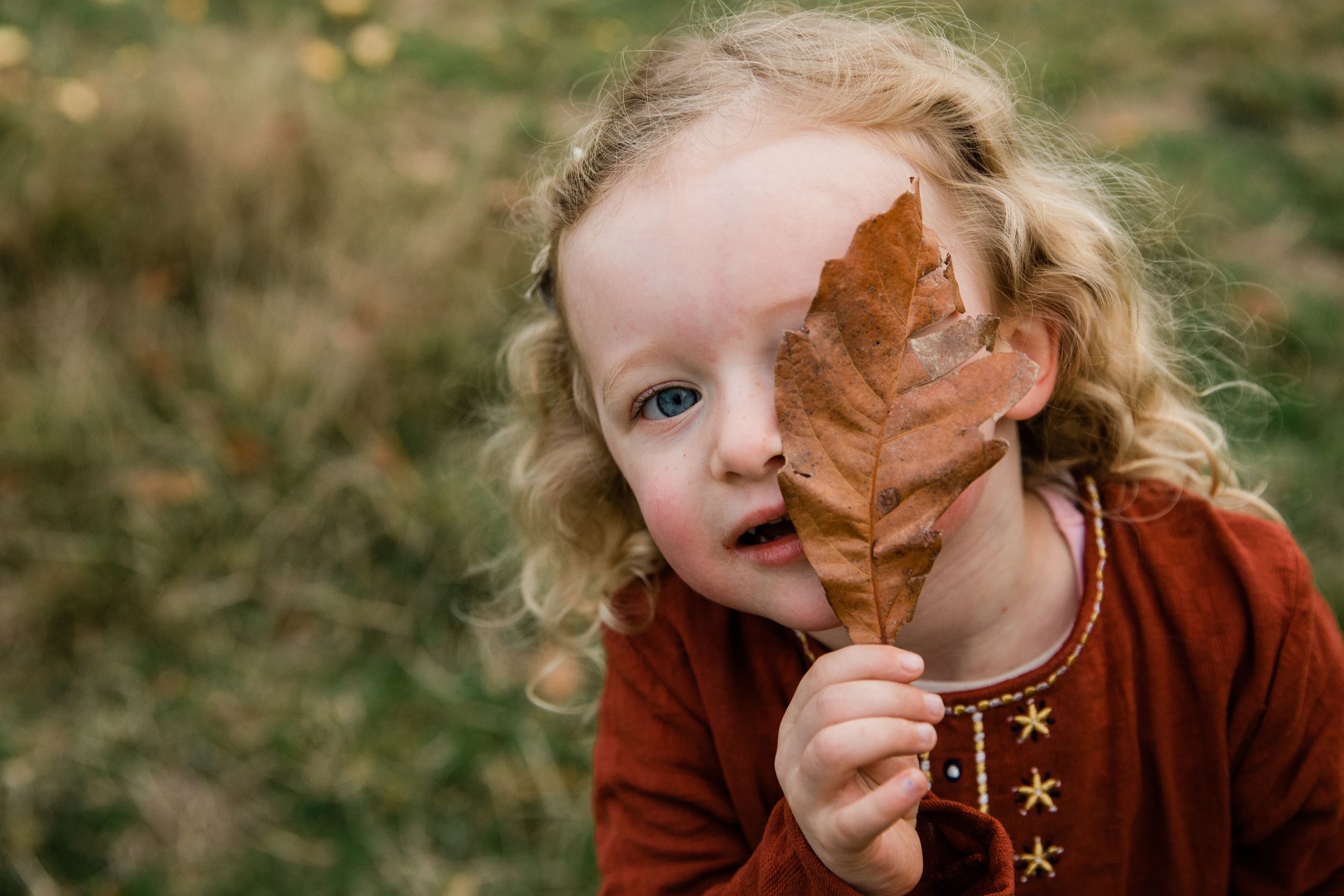toddler holding an autumn leaf