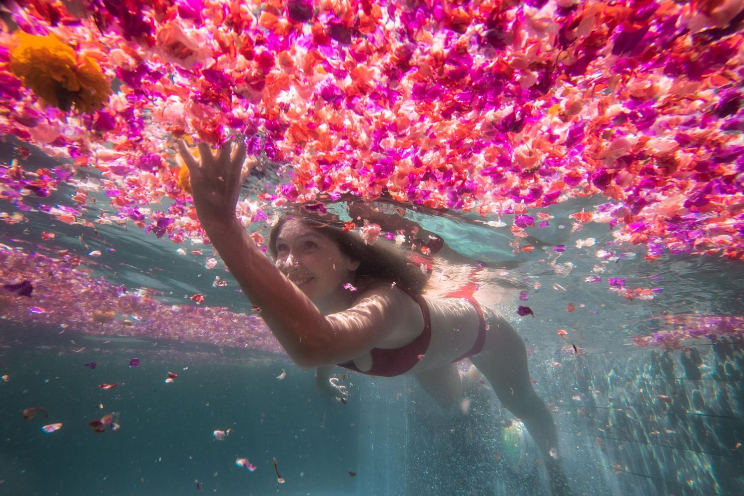 A girl reaching for a flower underwater