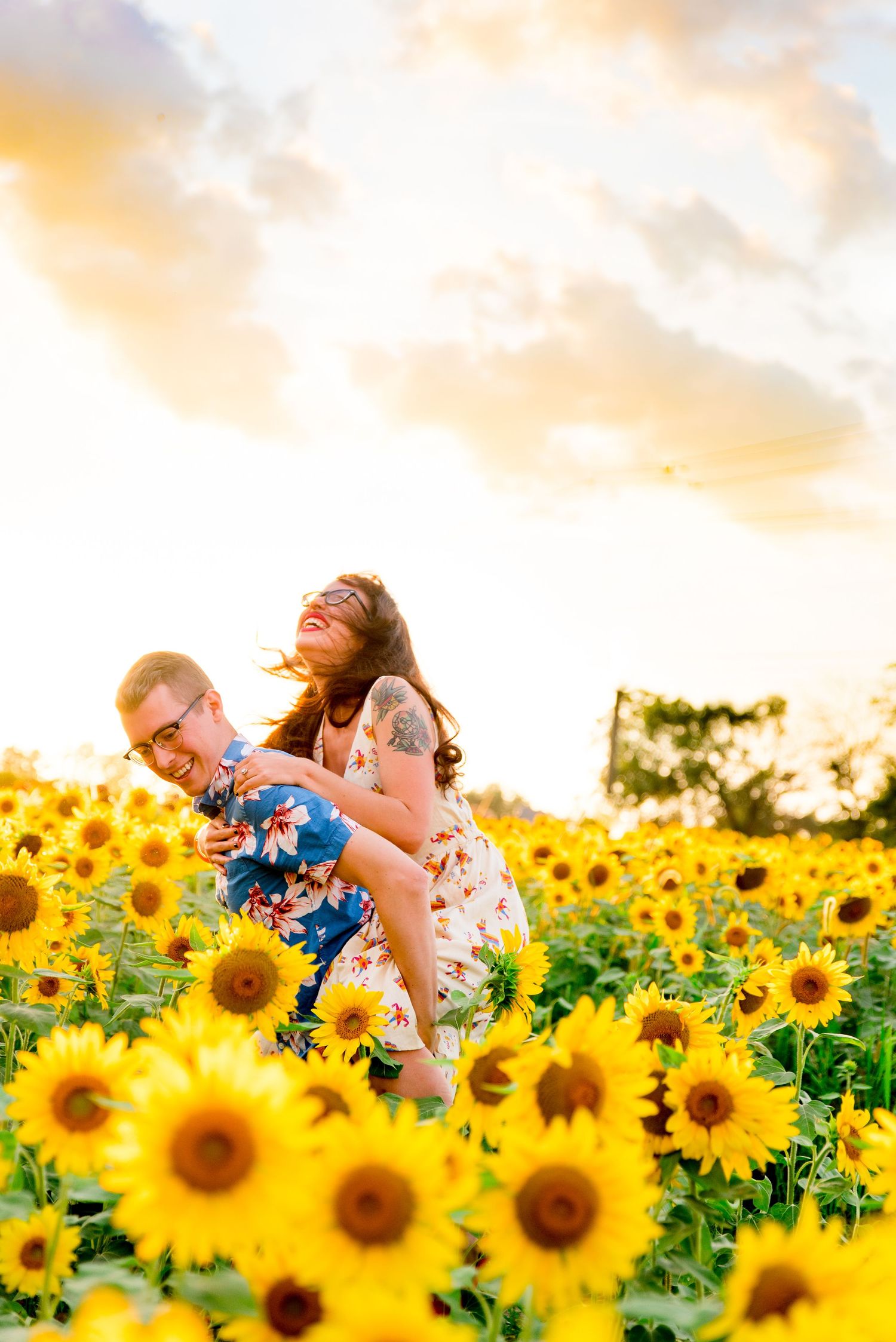laughing engaged couple doing a piggyback ride in a sunflower field at sunset in Chicago