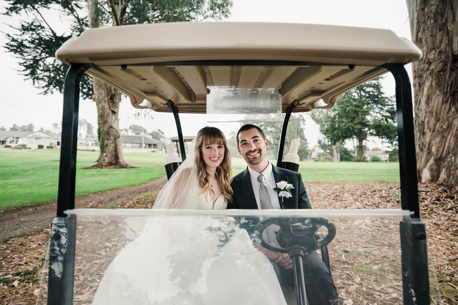 Bride and groom sitting in the golf cart after doing couples portraits down on the golf course