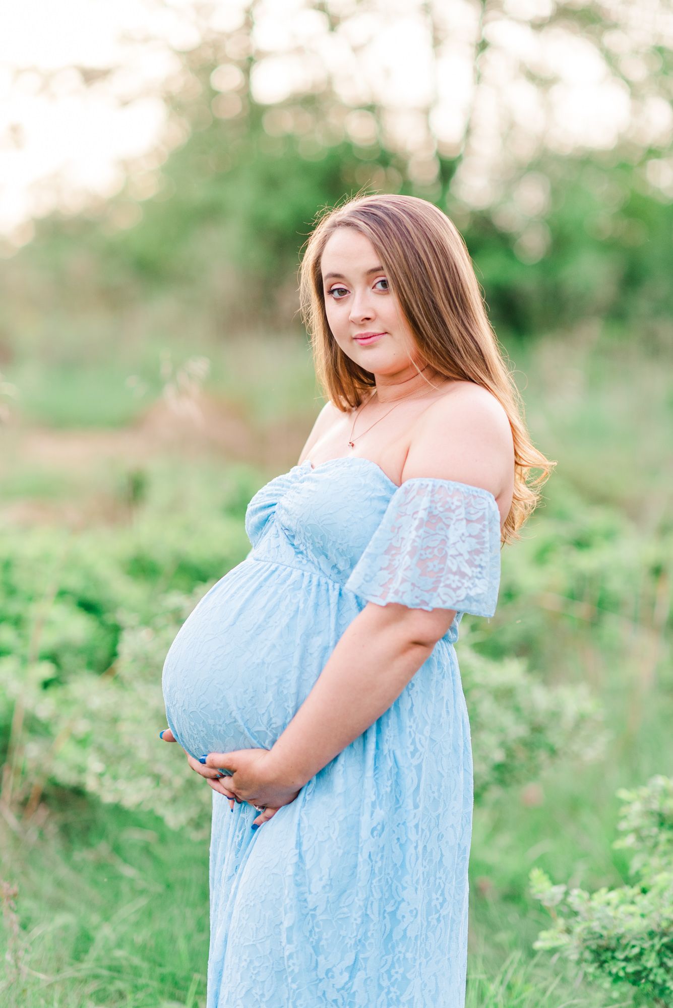 Maternity session with couple in field in golden hour sunlight at Moraine State Park, Pennsylvania