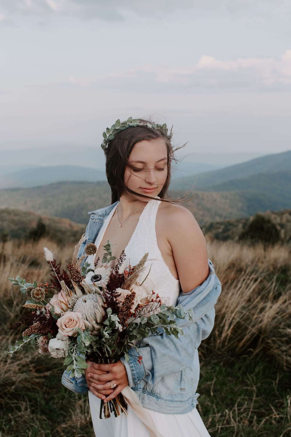 North Carolina elopement bride on top of a mountain with the wind blowing through her hair. Audrey Darke Photography