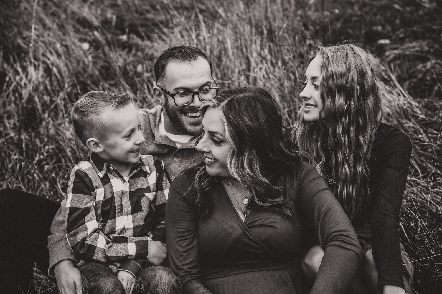 liz the photographer from greeley colorado took this picture of a family of 4 sitting down interacting with each other smiling for the pict