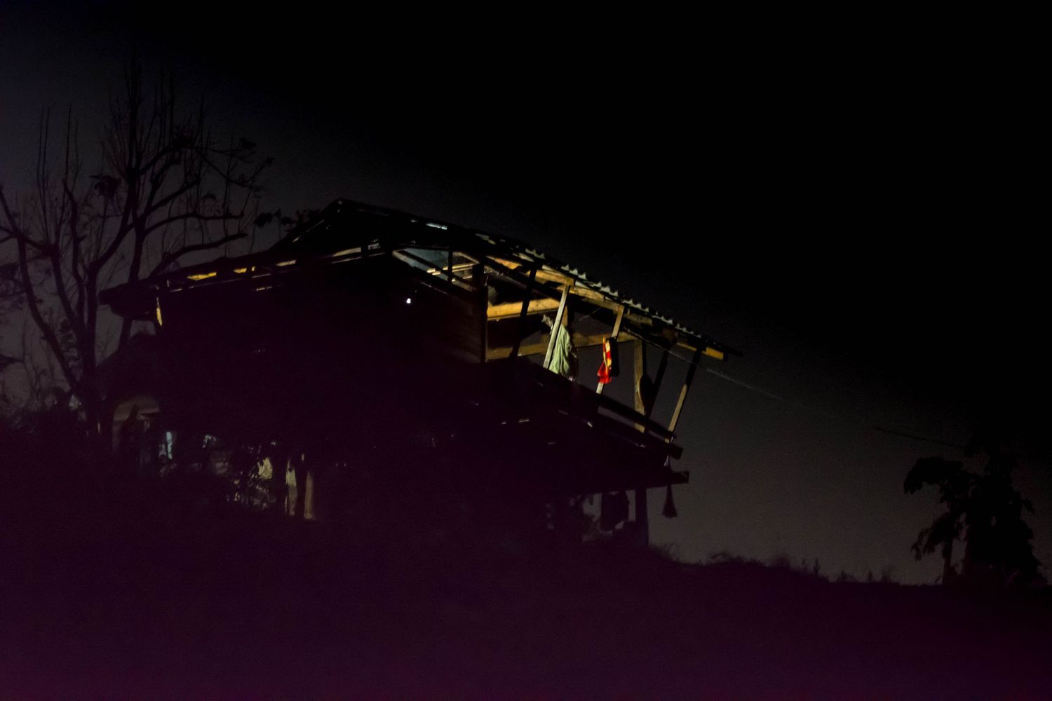Night sky and glowing lights of Akha Tribe house in Mountains of Northern Thailand