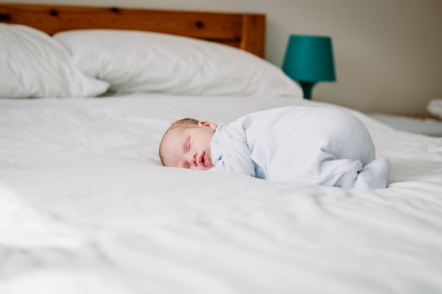 A newborn baby boy photographed on a bed by Hannah Veale Family Photographer in Oxfordshire.