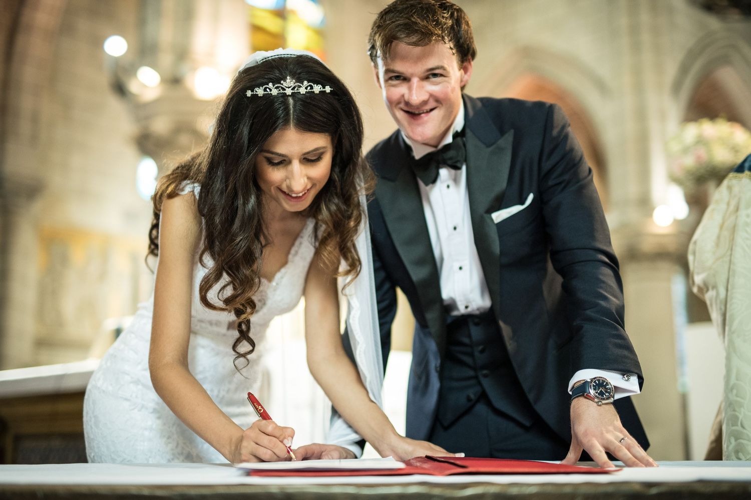 newlyweds sign their marriage register in French church