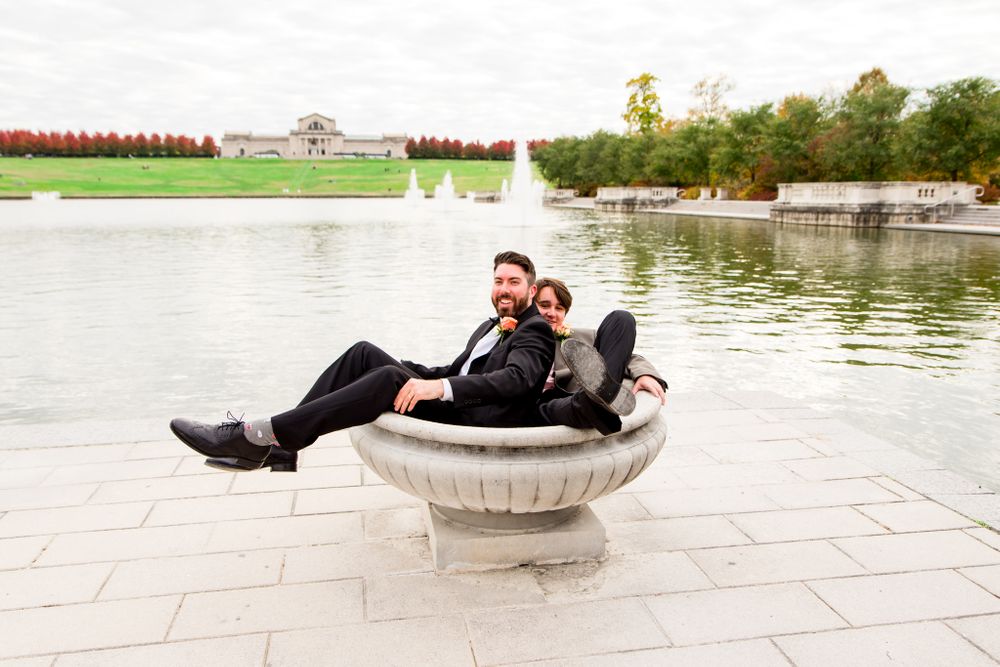 groom and groomsmen sit in bird bath at STL Forest Park groomsmen portraits