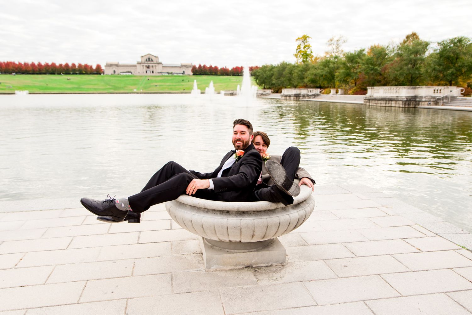 groom and groomsmen sit in bird bath at STL Forest Park groomsmen portraits