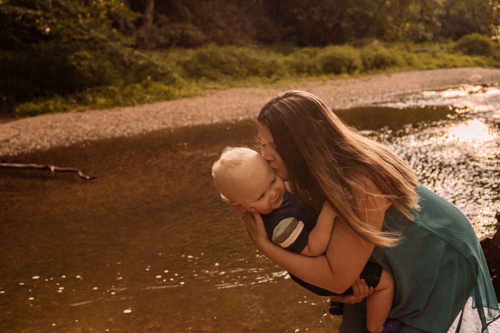 a loving moment between mom and son standing in the creek mastodon state park imperial mo st louis family photographer