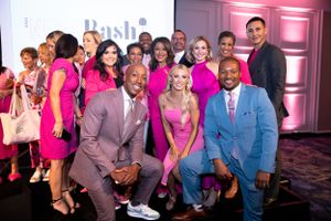 Group photo of News Anchors in pink and blue formal attire posing together.