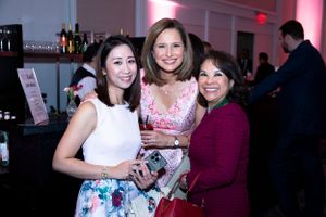 News Anchors smile together near bar area at formal evening event.