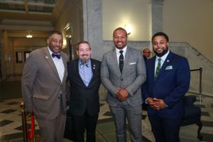 News Anchor Darren Haynes and Senator Nick Charles pose for photo in government building hallway.
