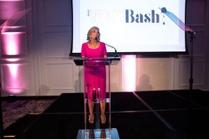 FLOTUS Jill Biden speaks at podium with News Bash logo displayed on screen behind.
