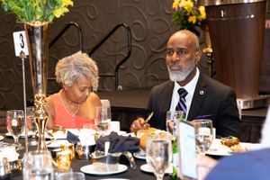 Guests enjoying a formal dinner at an elegantly decorated table.