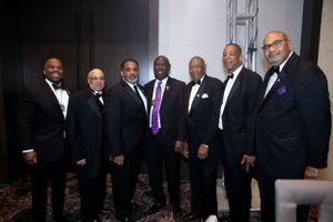 Group of men with Ben Crampon in formal black tie attire pose together at an evening event.