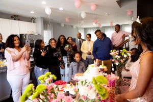 Party guests gathered together to celebrate with balloons and flowers decorating the space.