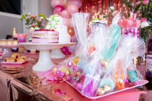 Dessert table with pink decor and wrapped party favors at celebration event.
